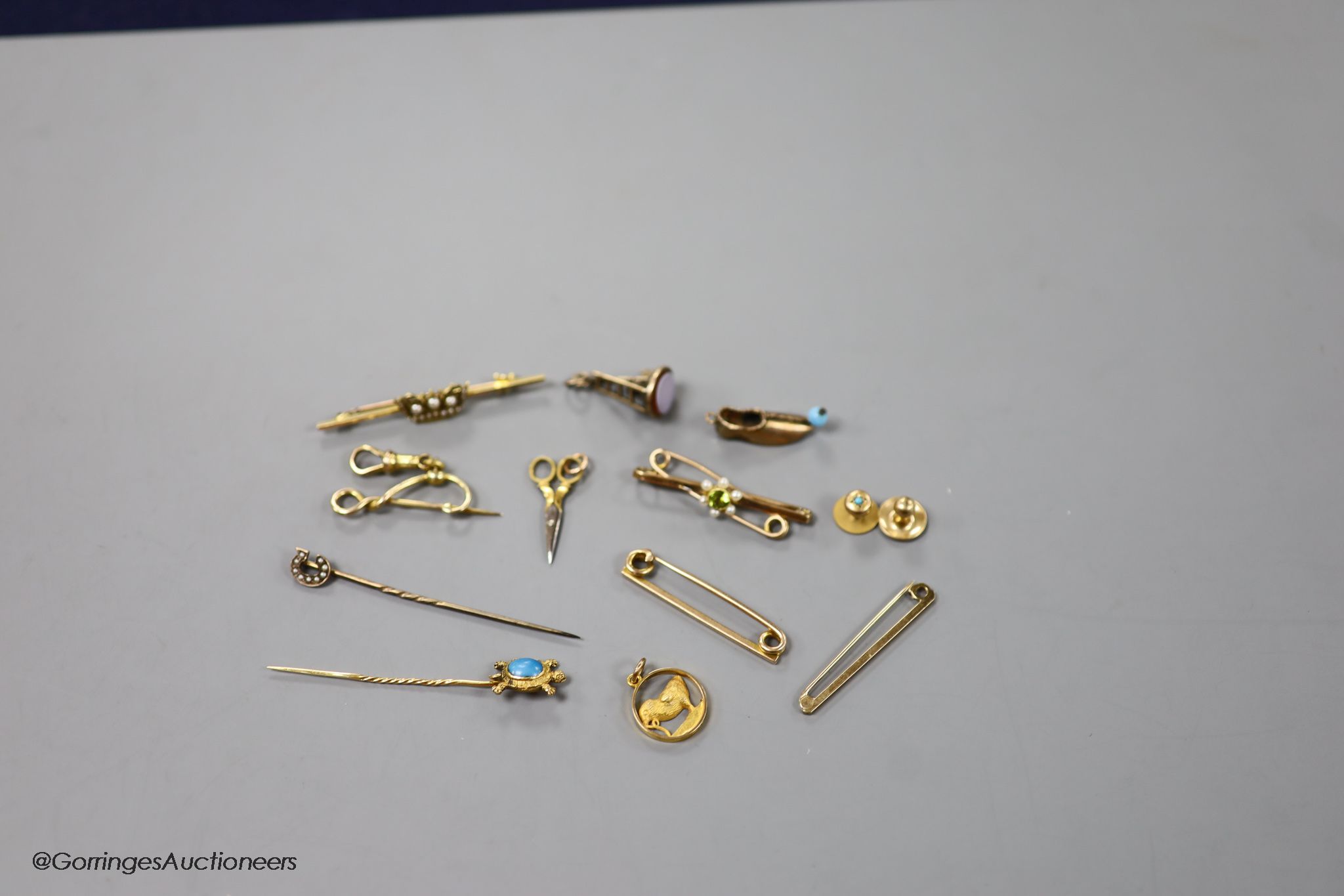 A small collection of stick pins, 'ladder and key' fob seal, bar brooches and charms etc. including 15ct and seed pearl coronet bar brooch, 50mm, gross 3.4 grams